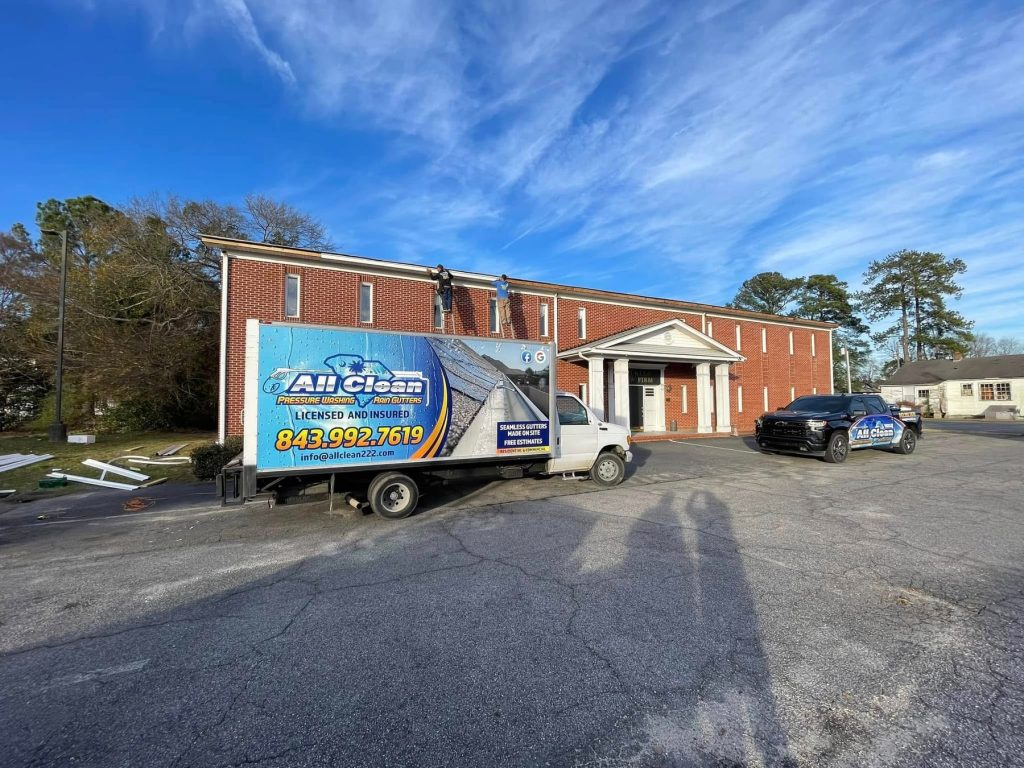 All Clean Rain Gutters crew installing gutters on a commercial brick building