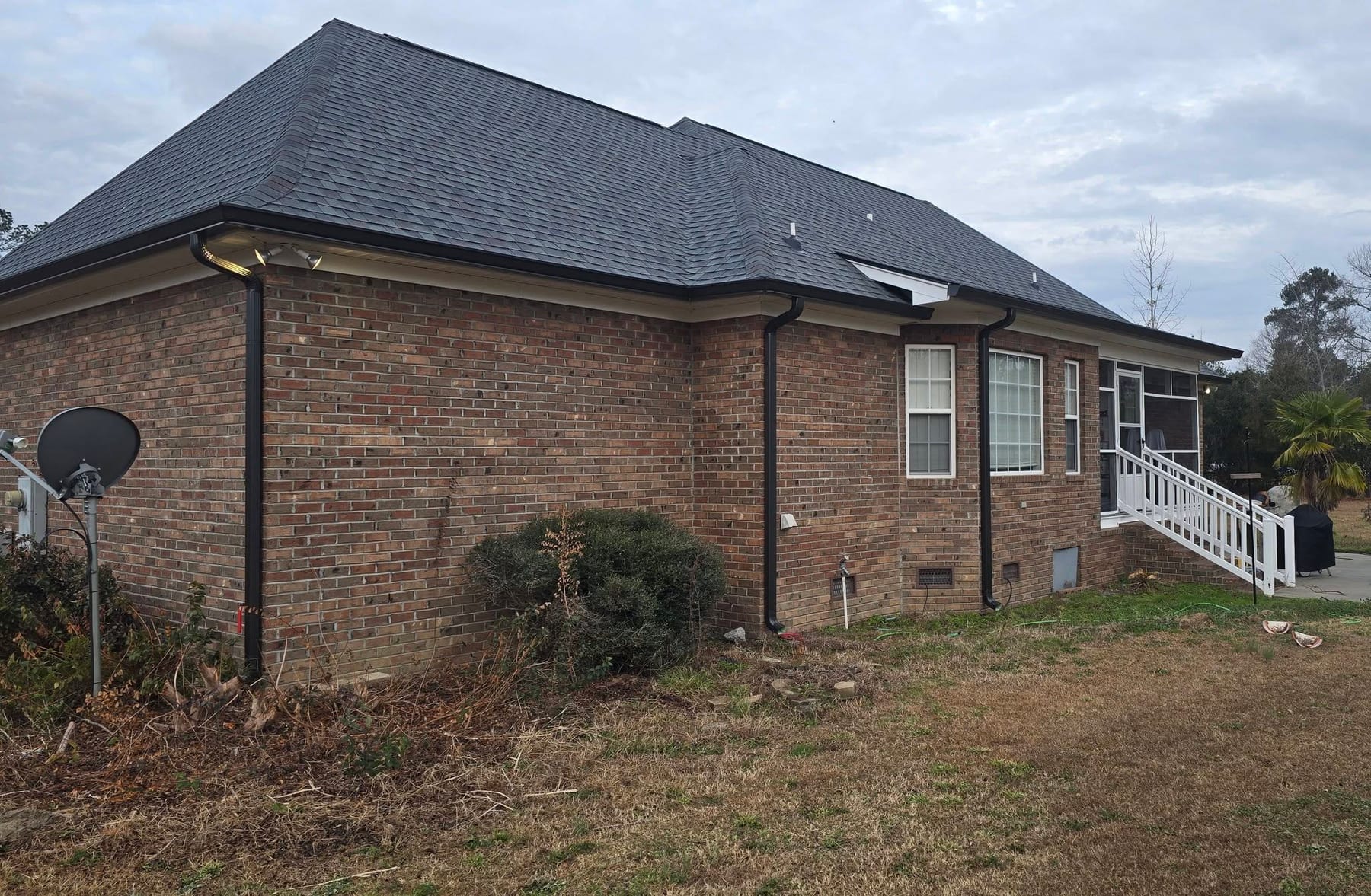Brick ranch home with new black seamless gutters