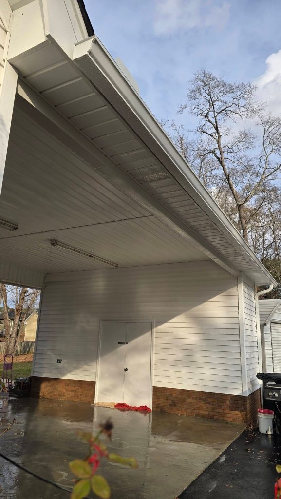 Carport and garage with white seamless gutters after rain