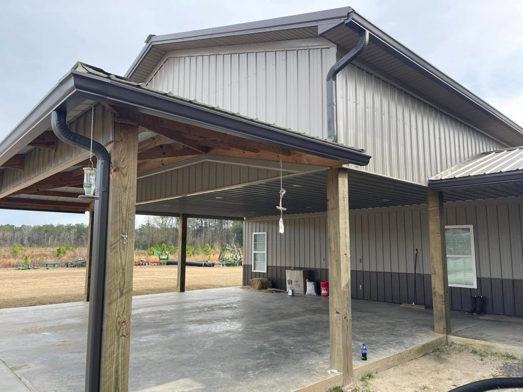 Commercial metal building with bronze seamless gutters and oversized downspouts
