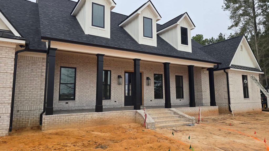 Modern brick farmhouse with black seamless aluminum gutters and downspouts
