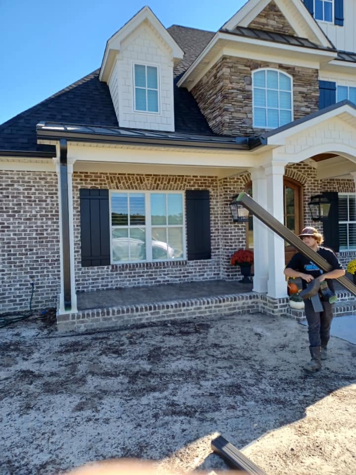 All Clean installer carrying a full-length seamless gutter run at a job site