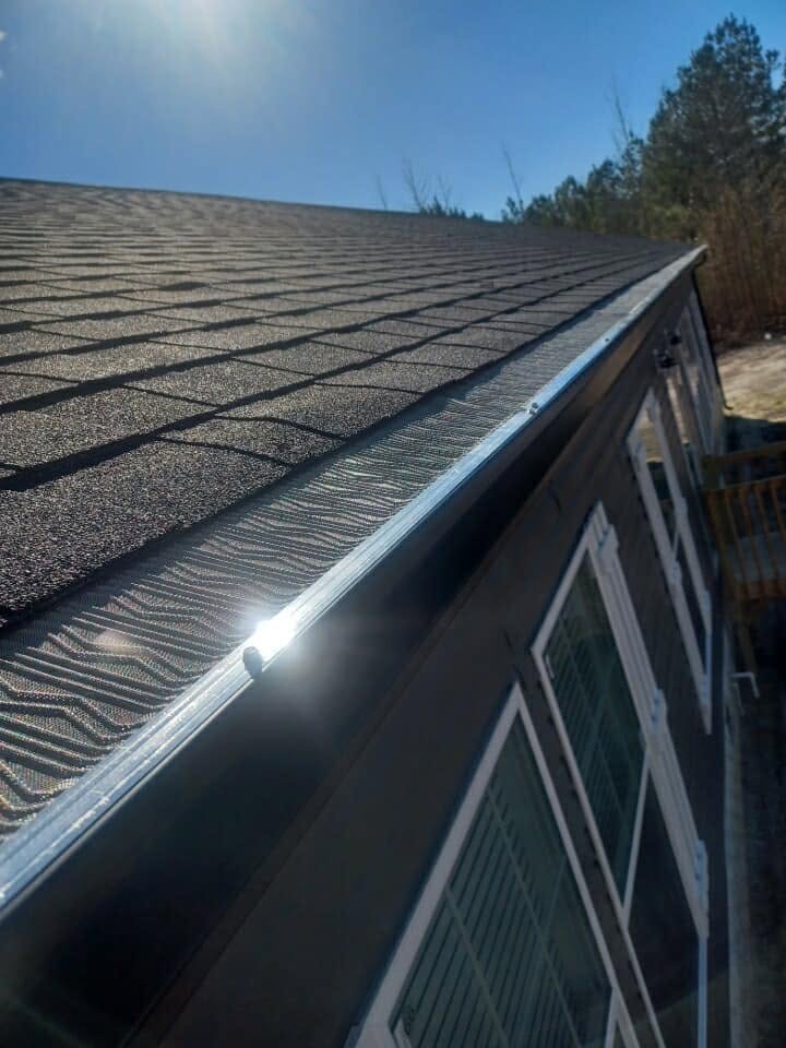 Close-up of micro-mesh leaf guard along a sunlit roof edge