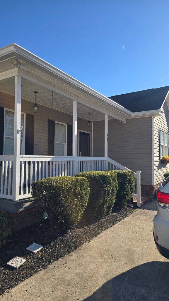 Tan sided home with white seamless gutters above the front porch