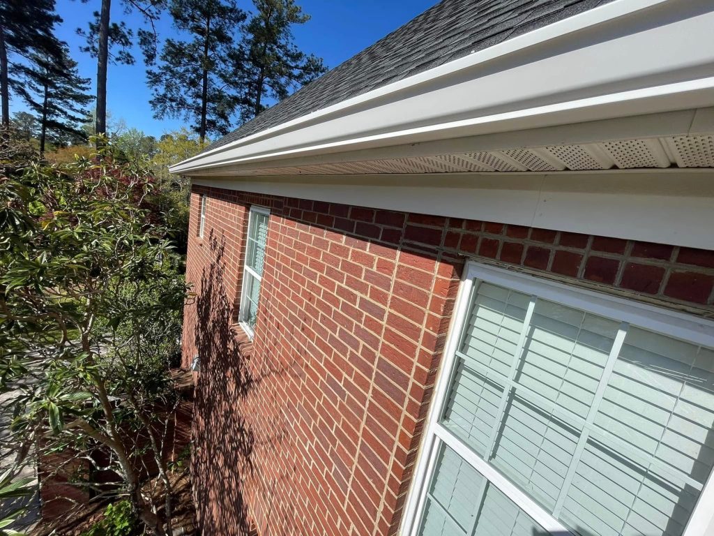 White seamless aluminum gutter and soffit detail on a red brick home